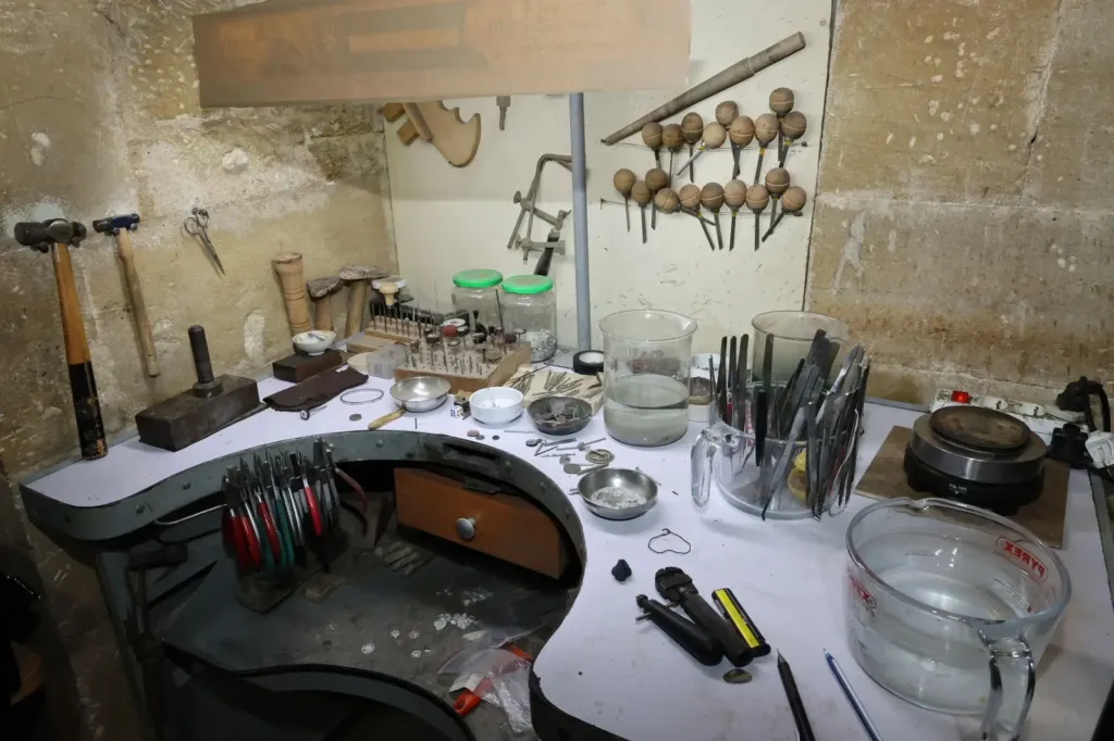 Werkplaats van een goudsmid met tangen, vijlen en een werkbank vol gereedschap